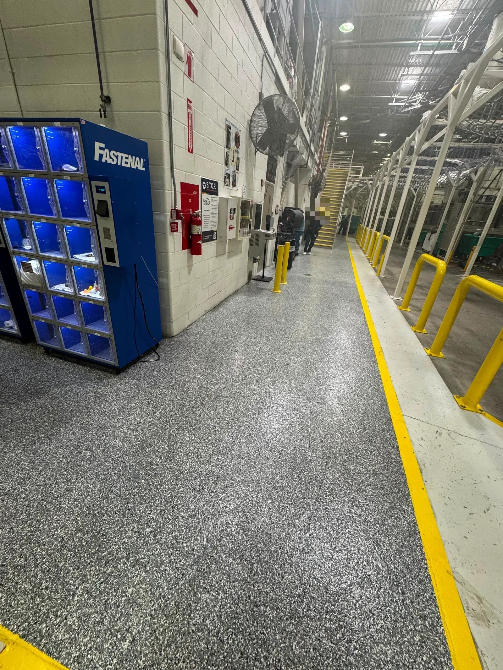 Warehouse aisle with a flake epoxy floor and a yellow safety line